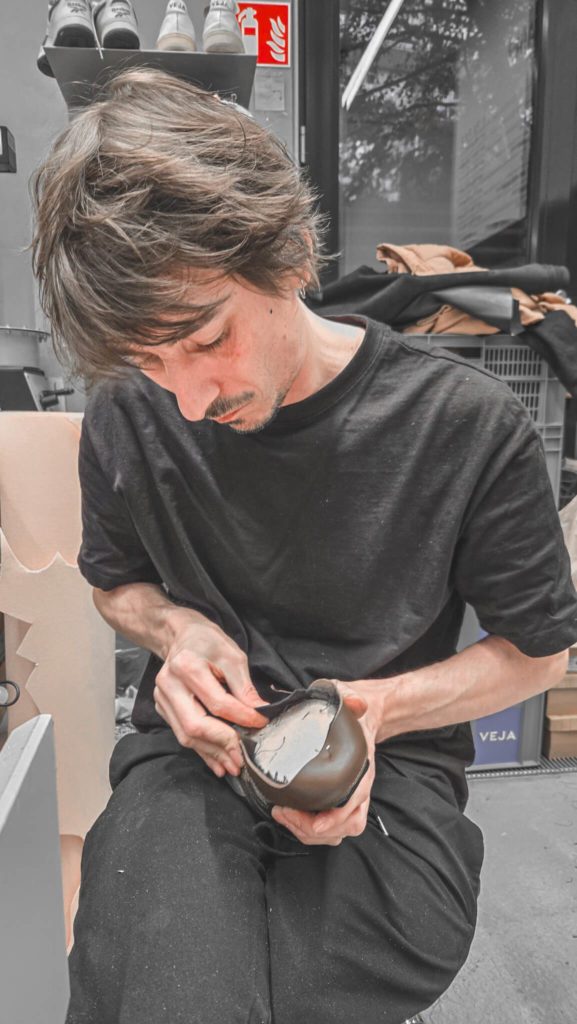 Ben, VEJA’s skilled cobbler, focused on crafting a custom VEJA Dekkan model, with the sounds of his tools blending seamlessly into the ambiance of the evening."